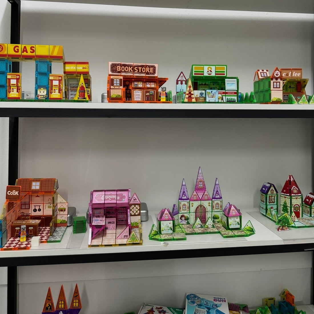 Magnetic building tiles display sets built as a gas station, bookstore, convenience store, coffee shop and castle